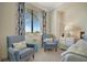 Cozy bedroom with a sitting area that features comfortable armchairs and a view of the outside at 5710 Palmer Cir # 105, Bradenton, FL 34211