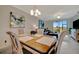 Open dining area with stylish decor, chandelier lighting, and sliding glass doors to the lanai at 5710 Palmer Cir # 105, Bradenton, FL 34211