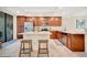 Bright kitchen featuring stainless appliances, granite countertops, an island, and wood cabinets at 5710 Palmer Cir # 105, Bradenton, FL 34211