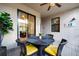 Cozy covered patio featuring a woven dining set, ceiling fan, and view of the home's interior at 5710 Palmer Cir # 105, Bradenton, FL 34211