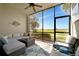 Screened porch features a comfortable sofa, chair and open views to the outdoors at 5710 Palmer Cir # 105, Bradenton, FL 34211