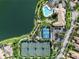 Aerial view of community with pool, clubhouse, tennis, and basketball courts by a lake at 5907 Guarino Dr, Sarasota, FL 34238