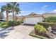 Home featuring a two-car garage with a brick-paved driveway and meticulous landscaping at 5907 Guarino Dr, Sarasota, FL 34238