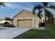 Attached two-car garage with a long driveway, surrounded by well-kept landscaping and mature trees at 7113 91St E St, Palmetto, FL 34221