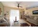 Bright living room featuring neutral sofas, a ceiling fan, and sliding doors to the outdoors at 7113 91St E St, Palmetto, FL 34221