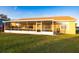 A screened porch extends the living space to a grassy backyard, ideal for outdoor relaxation and entertainment at 7113 91St E St, Palmetto, FL 34221