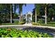 Exterior of grand clubhouse framed by palm trees and tropical landscaping, with circular drive at 850 S Tamiami Trl # 301, Sarasota, FL 34236