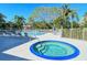 Community pool area with hot tub, plenty of lounge seating, and lush tropical landscaping at 850 S Tamiami Trl # 301, Sarasota, FL 34236