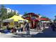Outdoor street market featuring food stalls, a double-decker bus, and many shoppers at 850 S Tamiami Trl # 301, Sarasota, FL 34236