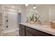 Modern bathroom with a double sink vanity, decorative mirror, and bright white tiled shower at 8612 Milestone Dr, Sarasota, FL 34238