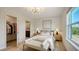 Bright bedroom with a large bed, a ceiling fan, and an attached ensuite bathroom and walk-in closet at 8612 Milestone Dr, Sarasota, FL 34238