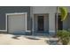 Welcoming townhome entrance with a modern door, adjacent garage, and neat landscaping at 8612 Milestone Dr, Sarasota, FL 34238