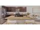 Open-concept kitchen featuring granite countertops, stainless steel appliances, and a cozy breakfast bar at 8612 Milestone Dr, Sarasota, FL 34238