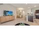 Open concept living space with a tv, dining area, kitchen with barstool seating, and modern finishes at 8612 Milestone Dr, Sarasota, FL 34238