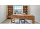 Bright office with a modern desk, stylish chair, and elegant white shelving units at 8612 Milestone Dr, Sarasota, FL 34238
