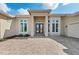 Elegant home featuring a paver parking area leading to a striking entrance with double doors and large picture windows at 9641 Carnoustie Pl, Bradenton, FL 34211