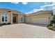 Charming single-story home shows off a large paver driveway leading up to its 2-car garage and grand double-door entrance at 9641 Carnoustie Pl, Bradenton, FL 34211