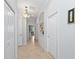 Bright hallway featuring neutral walls, tile floors, display niche, and doorways leading to other rooms in the home at 9641 Carnoustie Pl, Bradenton, FL 34211