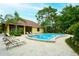 Inviting community pool featuring a covered pavilion, lounge chairs, and mature landscaping at 966 La Costa Cir # 1, Sarasota, FL 34237