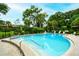 Inviting community pool with brick paved decking, surrounded by lush green landscaping at 966 La Costa Cir # 1, Sarasota, FL 34237
