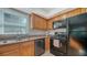 Bright kitchen with maple cabinets, granite counters, and black appliances at 966 La Costa Cir # 1, Sarasota, FL 34237