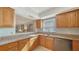 Cozy kitchen with wood cabinets, granite countertops, and stainless steel appliances at 966 La Costa Cir # 1, Sarasota, FL 34237