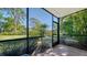 This is a screened lanai with views of mature trees and landscaping, providing a private retreat at 966 La Costa Cir # 1, Sarasota, FL 34237