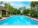 Community pool surrounded by lush landscaping and shaded seating areas for relaxation at 966 La Costa Cir # 1, Sarasota, FL 34237
