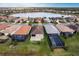 Aerial view of the home with a tile roof, screened-in lanai, and community lake at 11679 Renaissance Blvd, Venice, FL 34293