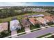 Aerial view of the home with a tile roof, attached garage, and serene pond in the backyard at 11679 Renaissance Blvd, Venice, FL 34293