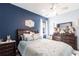 Comfortable bedroom showcases a dark blue wall, a queen bed, and decorative furniture at 11679 Renaissance Blvd, Venice, FL 34293
