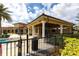 Clubhouse exterior featuring white columns, tan facade, tile roof and manicured landscaping at 11679 Renaissance Blvd, Venice, FL 34293