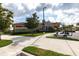 Gorgeous clubhouse featuring lush landscaping, stone accents, a golf cart, and ample parking at 11679 Renaissance Blvd, Venice, FL 34293