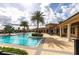 Lagoon style community pool with palm tree island, tables, chairs and clubhouse at 11679 Renaissance Blvd, Venice, FL 34293