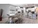 Bright open floor plan with gray plank flooring featuring dining and kitchen with modern white cabinetry at 11679 Renaissance Blvd, Venice, FL 34293