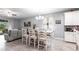 Bright dining area featuring a modern chandelier, an elegant dining table, and sleek gray flooring at 11679 Renaissance Blvd, Venice, FL 34293
