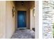 The elegant entrance to the home boasts a blue door with glass panels and stone detailing on the facade at 11679 Renaissance Blvd, Venice, FL 34293