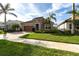 Charming single-story home featuring a well-manicured lawn, beautiful landscaping, and a stone facade at 11679 Renaissance Blvd, Venice, FL 34293