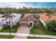 Aerial view of the home with a tile roof, paver driveway, and lush landscaping at 11679 Renaissance Blvd, Venice, FL 34293