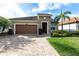 Charming single-story home with a brick driveway, two car garage and landscaped yard at 11679 Renaissance Blvd, Venice, FL 34293