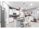 Bright kitchen with white cabinets, stainless steel appliances, granite countertops and pendant lighting at 11679 Renaissance Blvd, Venice, FL 34293