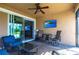 Relaxing outdoor lanai with a ceiling fan, TV, comfortable seating, and sliding glass doors at 11679 Renaissance Blvd, Venice, FL 34293