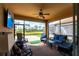 Relaxing screened-in patio with comfortable seating, ceiling fan, and views of the green lawn at 11679 Renaissance Blvd, Venice, FL 34293