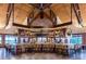 Clubhouse interior featuring a full bar, hardwood floors, custom shelving, and golf course views at 15520 Castle Park Ter, Lakewood Ranch, FL 34202