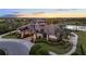 Beautiful clubhouse with tropical landscaping, outdoor pool, and sunset views over the golf course at 15520 Castle Park Ter, Lakewood Ranch, FL 34202