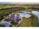 Aerial view of a tropical community pool with golf course views and a stunning clubhouse at 15520 Castle Park Ter, Lakewood Ranch, FL 34202