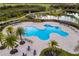 Large community pool with shaded seating areas and lounge chairs surrounded by palm trees at 15520 Castle Park Ter, Lakewood Ranch, FL 34202