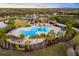 Aerial view of the community pool with palm trees, ample seating, and lush landscaping in a tropical setting at 15520 Castle Park Ter, Lakewood Ranch, FL 34202