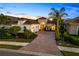 Beautifully landscaped home features a paver driveway and lush tropical landscaping with a barrel tile roof at 15520 Castle Park Ter, Lakewood Ranch, FL 34202