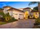 Elegant home showcasing a tile roof, white exterior, three-car garage, and beautifully landscaped front yard at 15520 Castle Park Ter, Lakewood Ranch, FL 34202